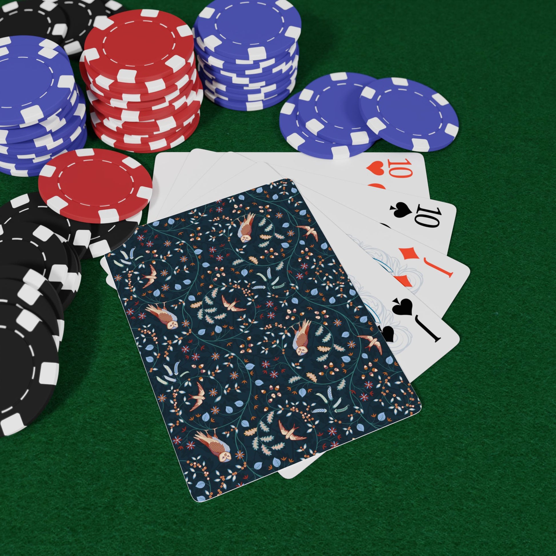 Poker chips and playing cards on a green felt surface