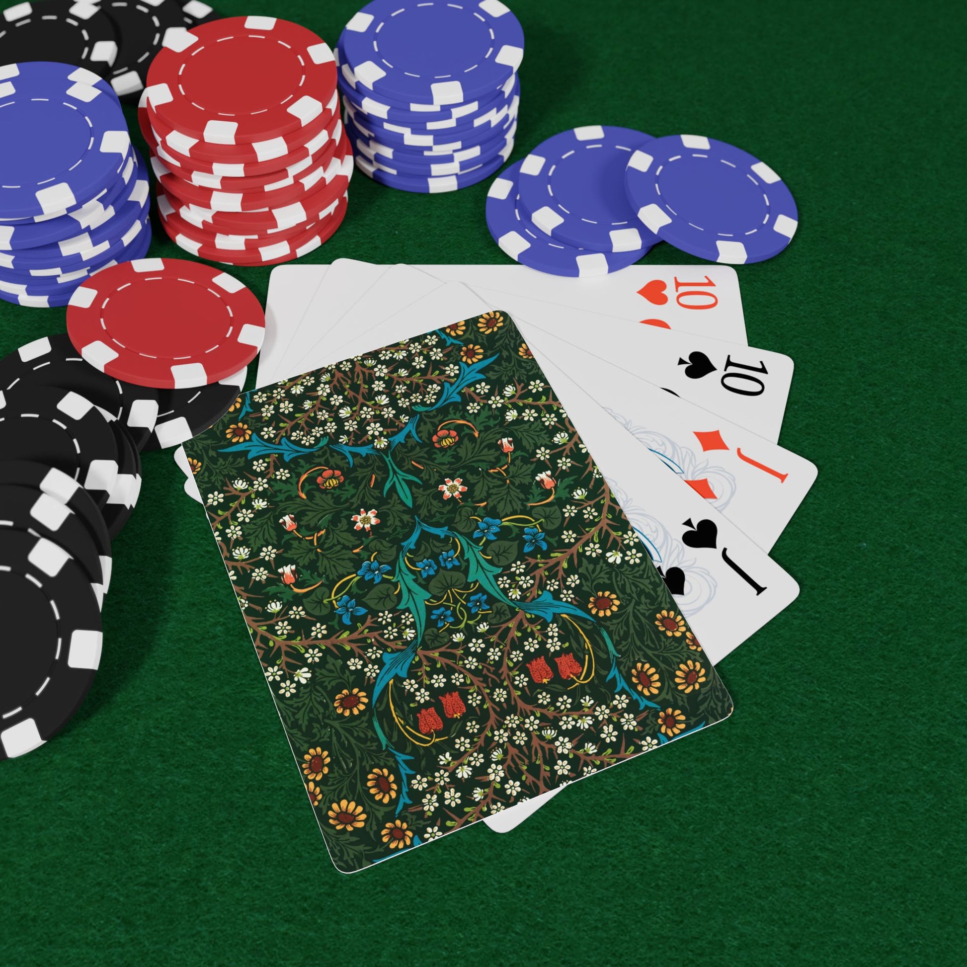 Poker chips and playing cards on a green felt surface
