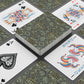Playing cards with decorative designs on a gray surface