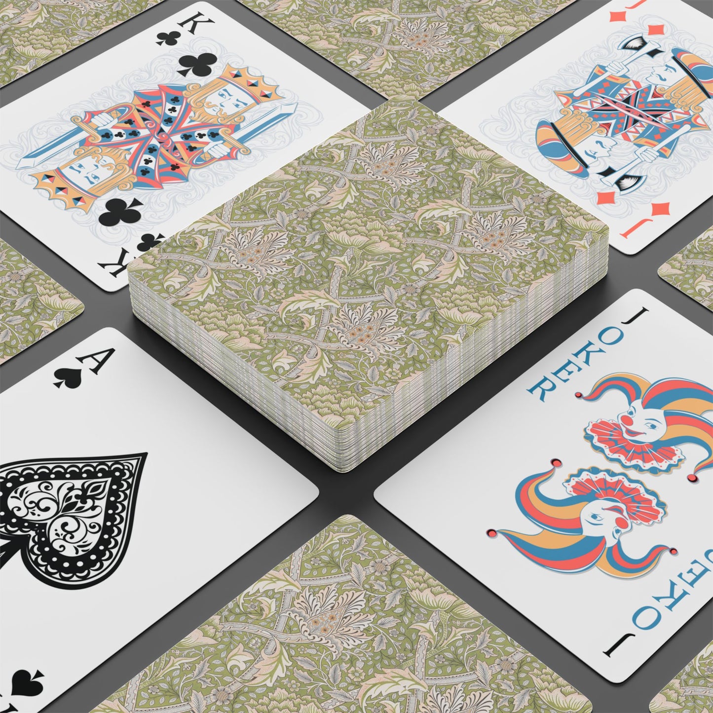 Playing cards with floral design and colorful joker card on a black surface