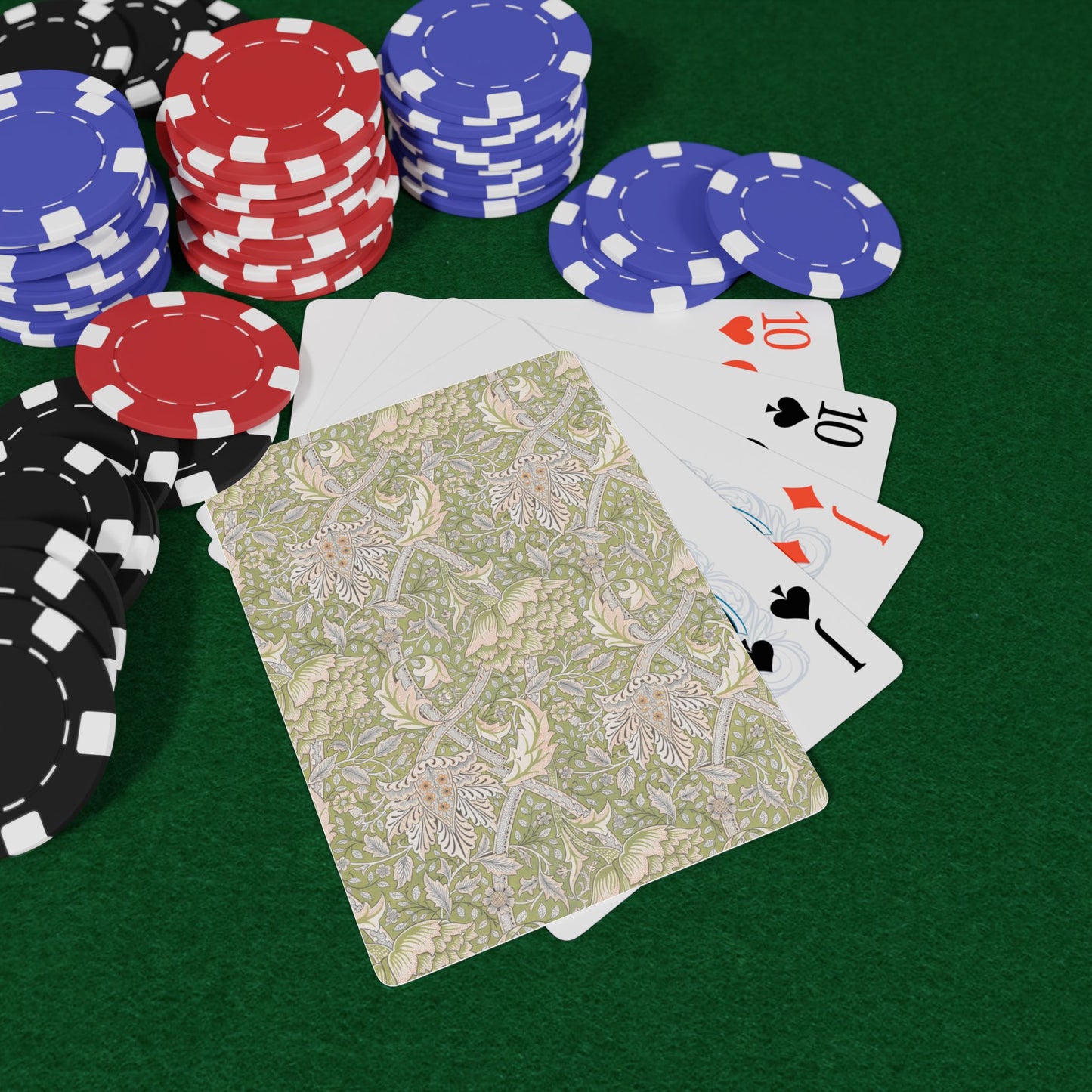 Poker chips and playing cards on a green felt surface