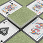 Playing cards with green patterned back and colorful front designs on a black surface