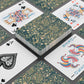 Playing cards with floral design and colorful joker card on a dark surface