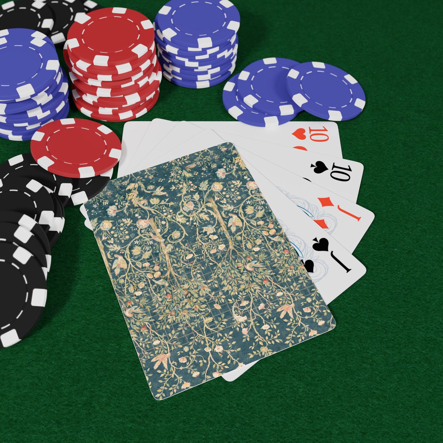 Poker chips and playing cards on a green felt surface