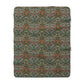 A cozy Sherpa Fleece Blanket with a geometric William Morris & Co pattern in a mix of dark and vibrant colours, laid out flat.