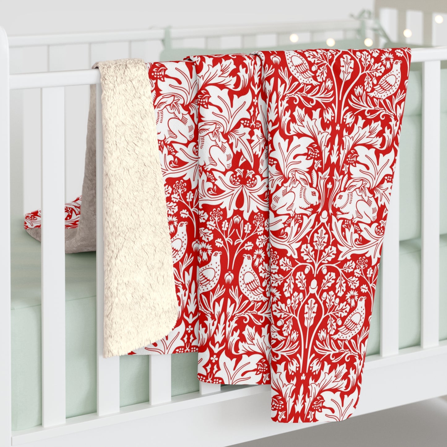 Red and white floral patterned blanket draped over a white crib.