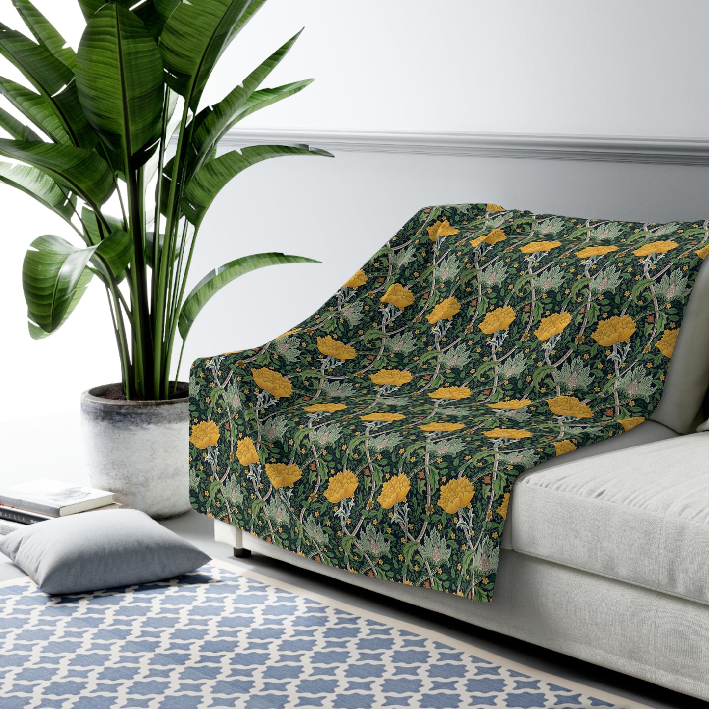 A plush fleece blanket with a yellow chrysanthemum pattern on a green background, laid flat.