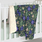 Floral patterned blanket draped over a white crib