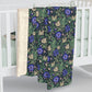 Floral patterned blanket draped over a crib with a white background