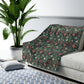 Floral-patterned throw blanket on a sofa in a living room with a plant and rug.
