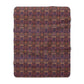 A plush fleece blanket with a floral William Morris & Co pattern in purple, pink and cream colours, folded neatly.