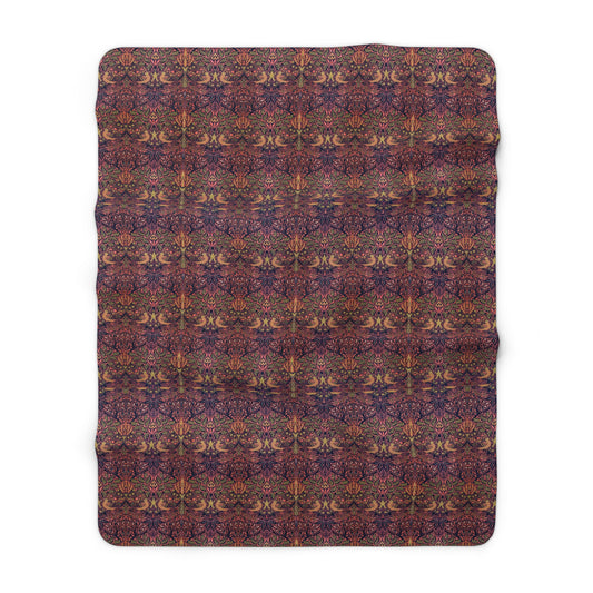 A plush fleece blanket with a floral William Morris & Co pattern in purple, pink and cream colours, folded neatly.