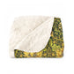 Blanket with white fleece interior and green floral exterior on a white background