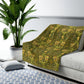 Sofa with a green patterned throw blanket in a living room setting.