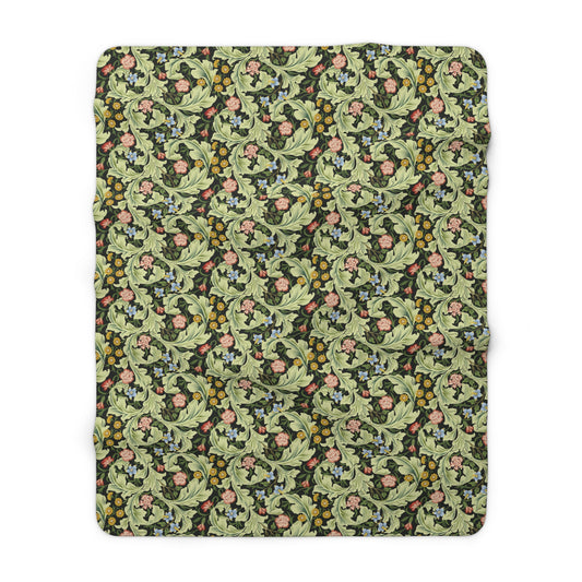 A green Sherpa fleece blanket with a floral pattern inspired by William Morris, displayed flat.