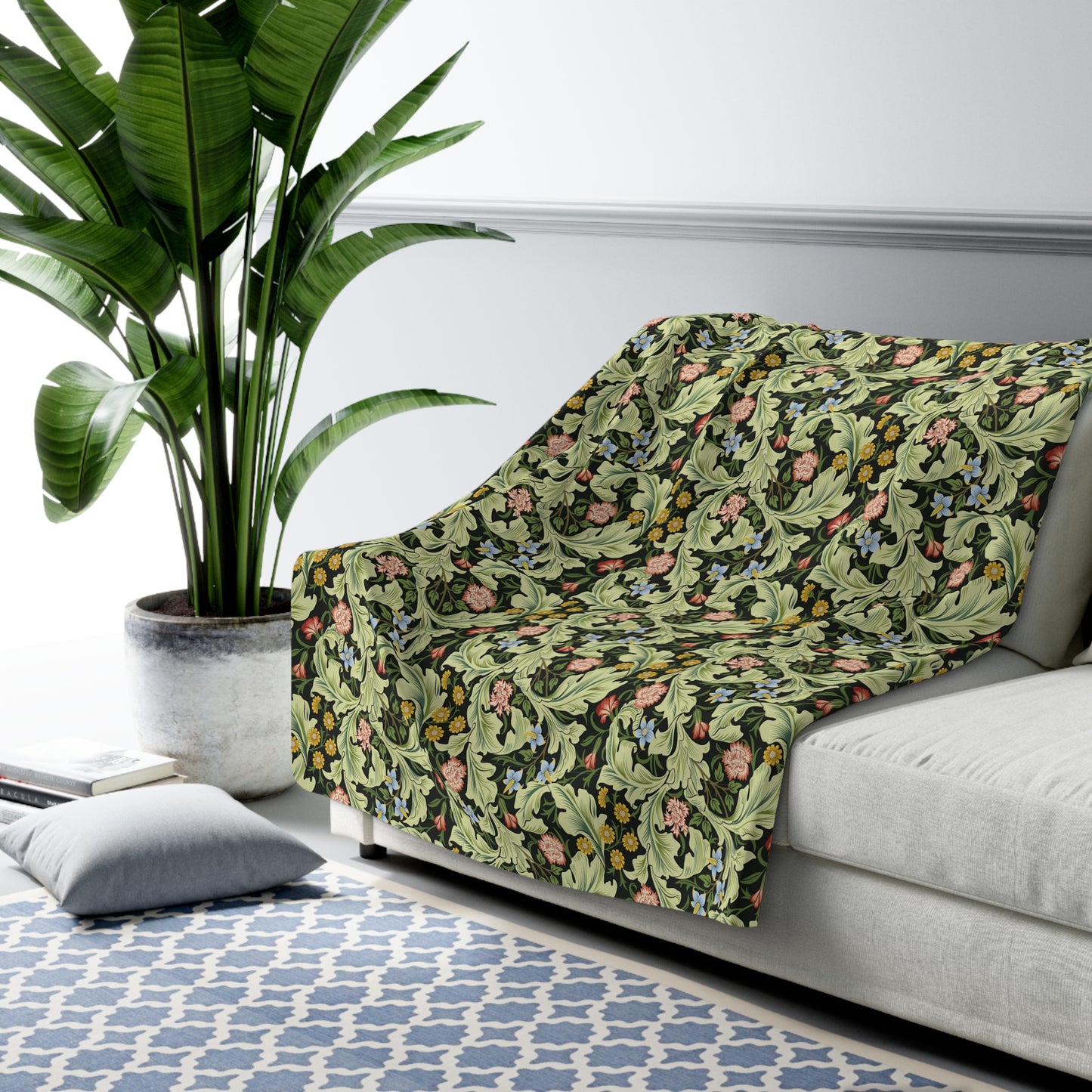 A green Sherpa fleece blanket with a floral pattern inspired by William Morris, displayed flat.