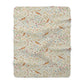 Floral and bird patterned blanket on a white background