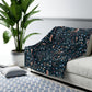 Sofa with a floral patterned cover in a living room setting with a plant and rug.