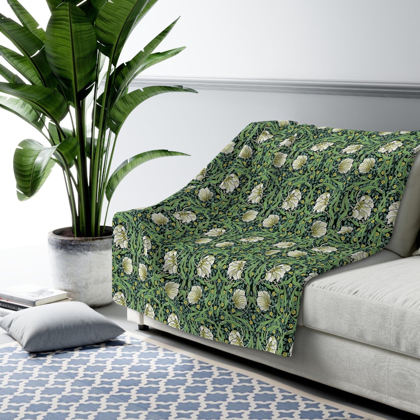 A green Sherpa fleece blanket with a floral pattern inspired by William Morris.