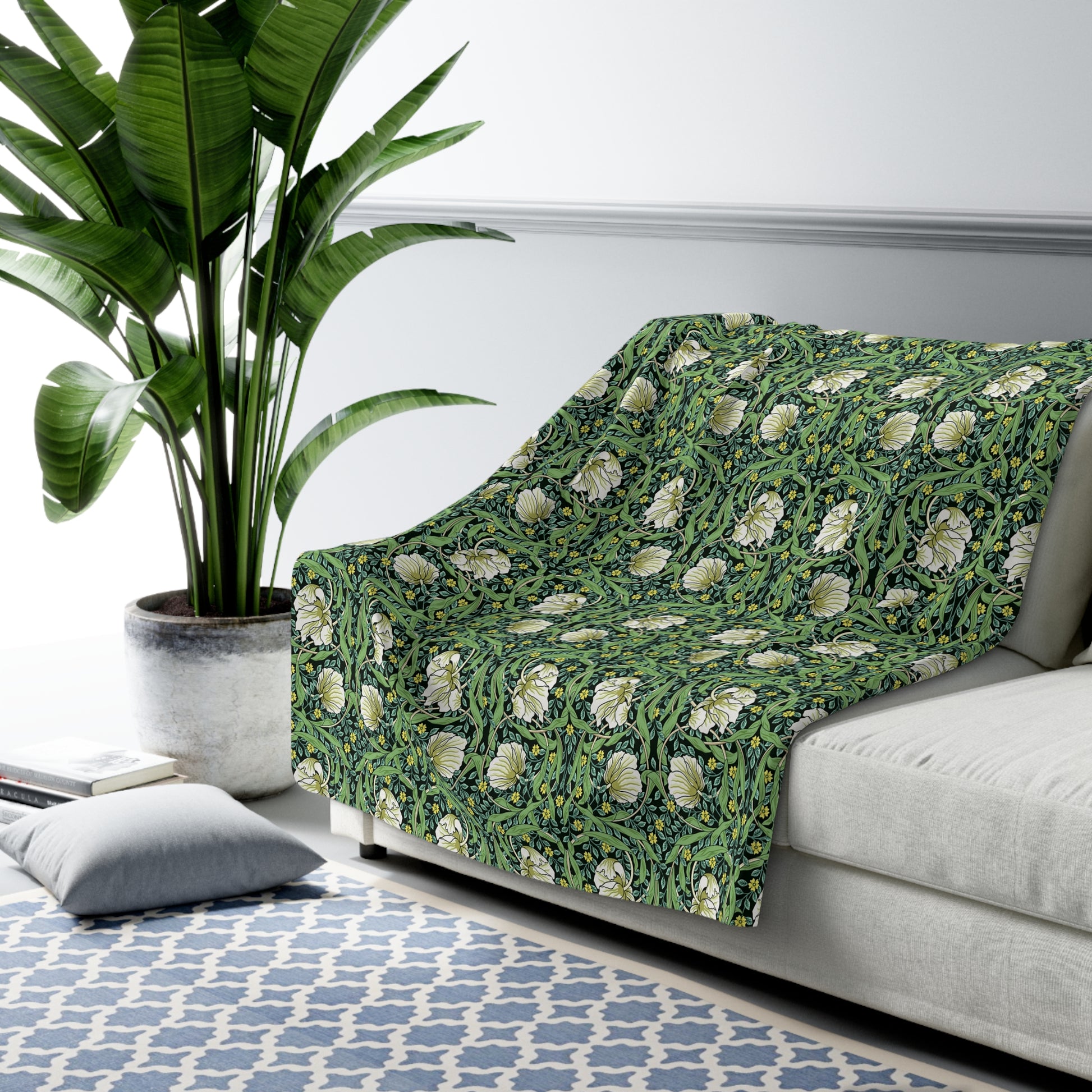 A green Sherpa fleece blanket with a floral pattern inspired by William Morris.