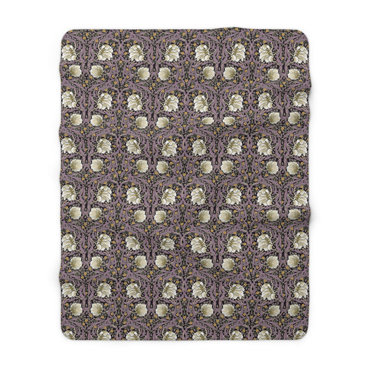 A plush fleece blanket with a floral pattern in a purple hue, inspired by William Morris, displayed on a white background.