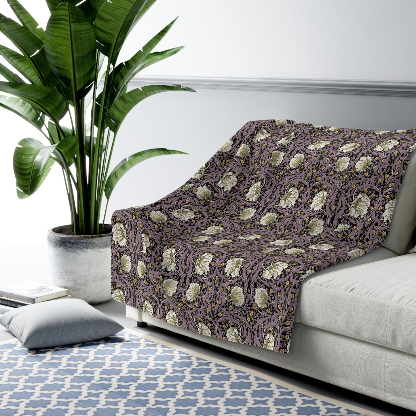 A plush fleece blanket with a floral pattern in a purple hue, inspired by William Morris, displayed on a white background.
