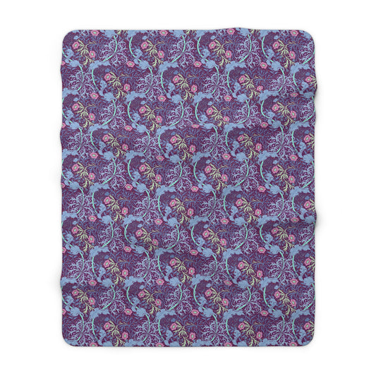 A rectangular Sherpa fleece blanket with a floral William Morris & Co pattern in pink and purple colours.