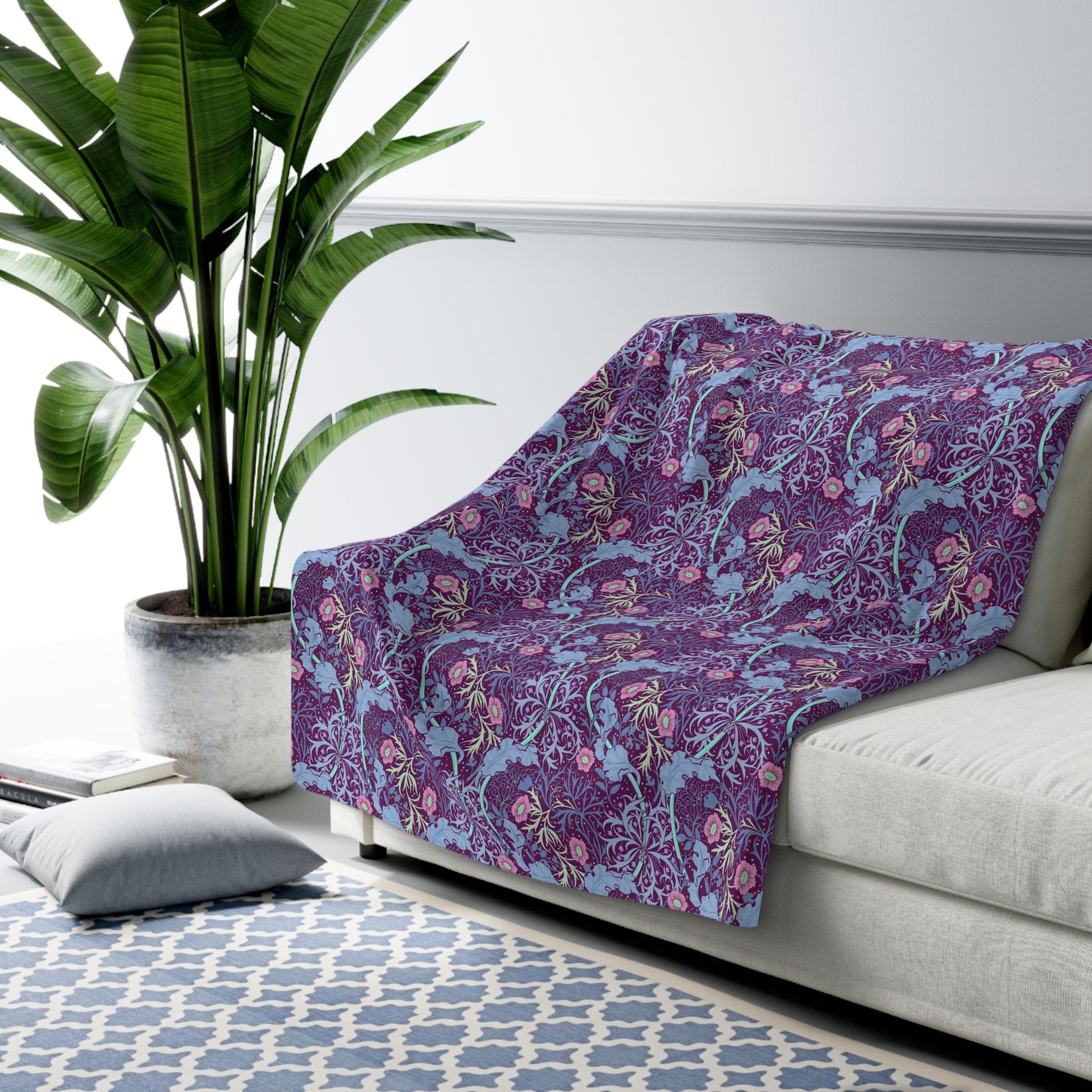 A rectangular Sherpa fleece blanket with a floral William Morris & Co pattern in pink and purple colours.