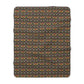 A Sherpa fleece blanket with a geometric pattern featuring birds and floral-like designs on a dark background.