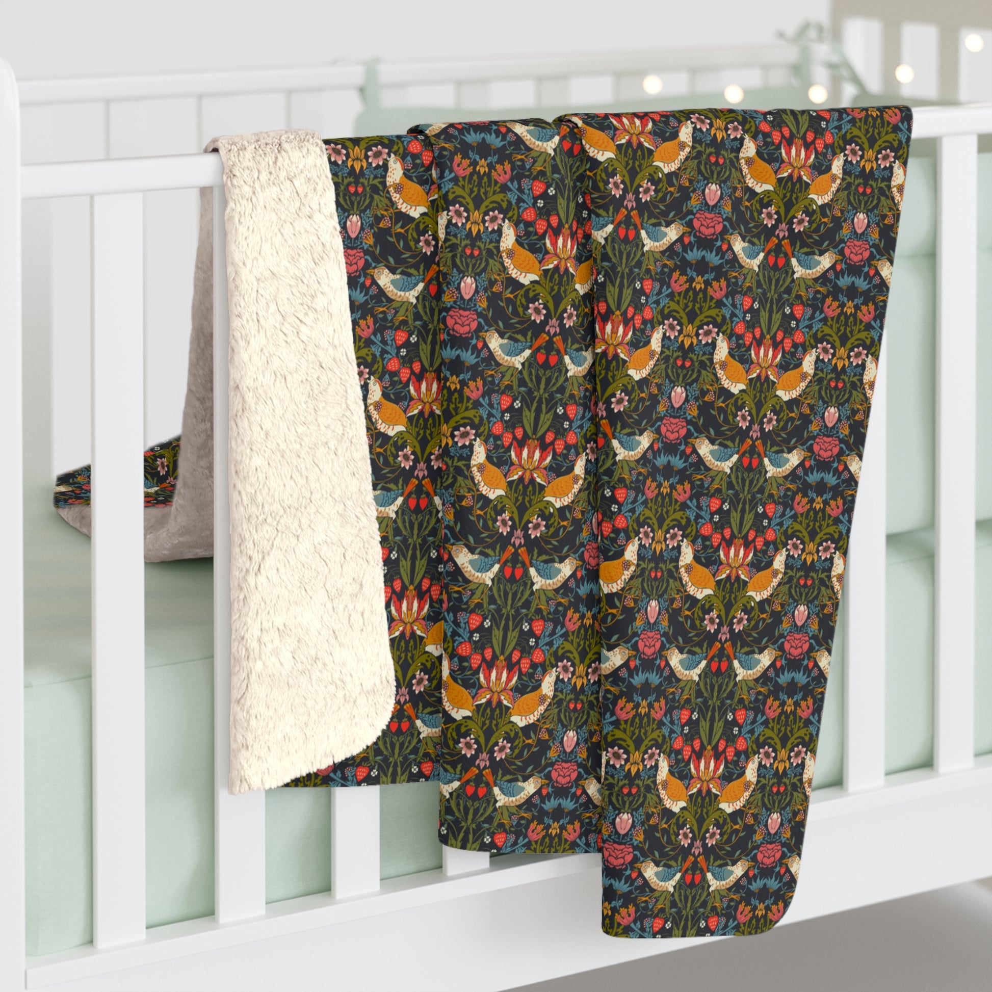 Floral and bird patterned blanket draped over a white crib