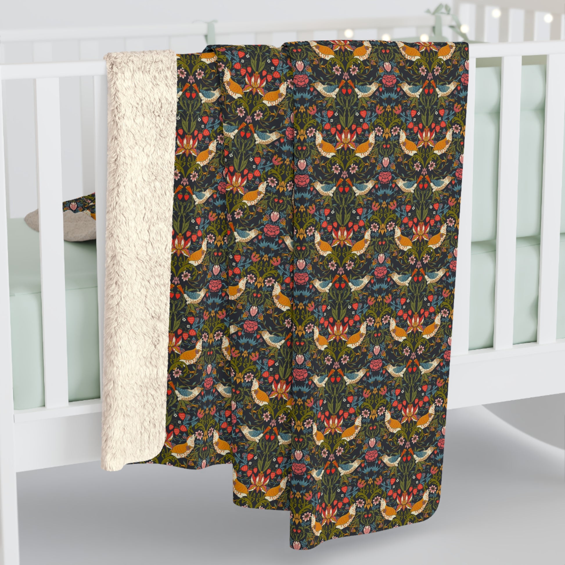 Decorative blanket with bird and floral pattern draped over a white crib.