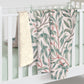 Floral-patterned blanket draped over a white crib