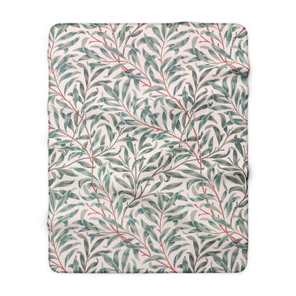 Floral patterned blanket with green leaves and red stems on a white background