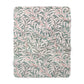 Floral patterned blanket with green leaves and red stems on a white background