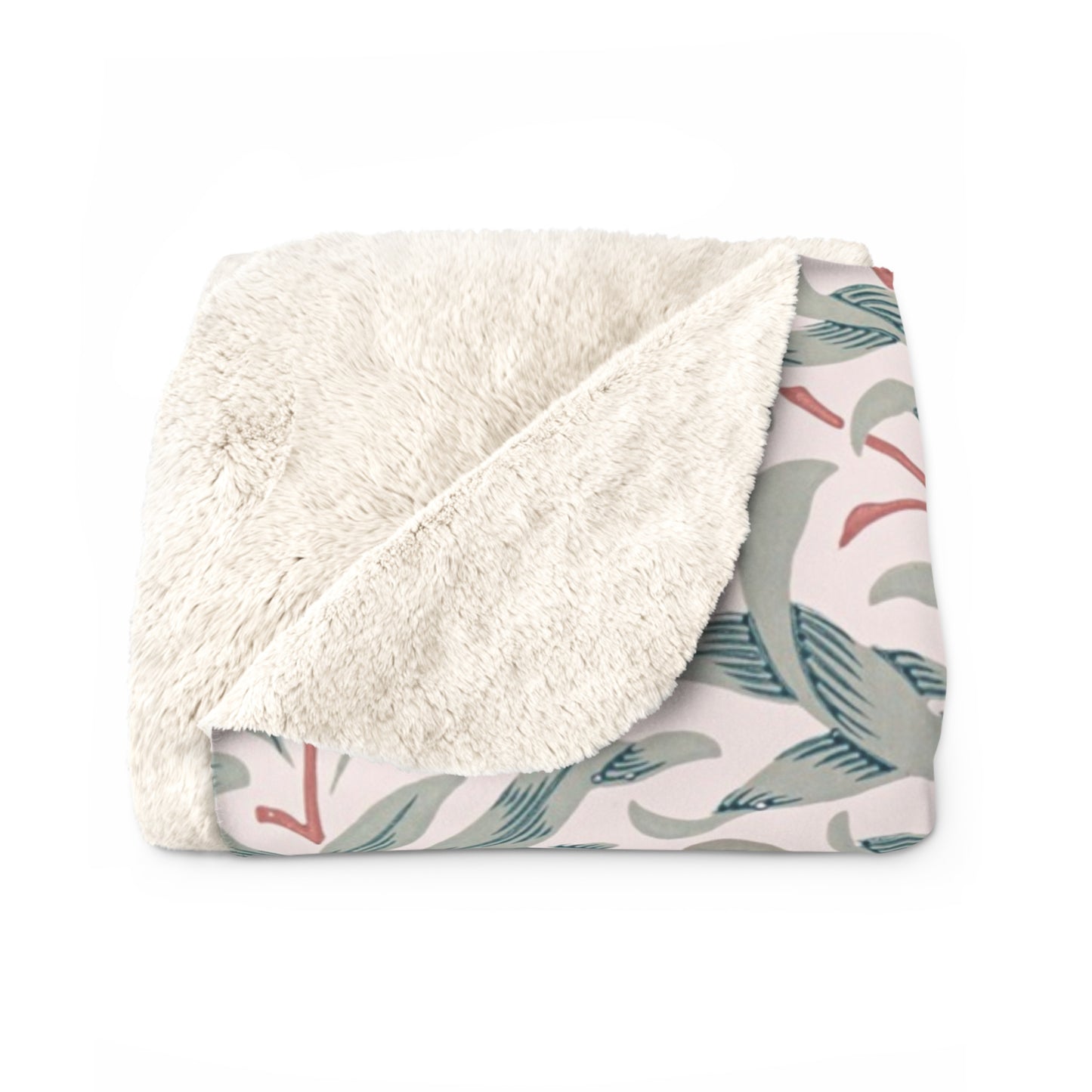 Folded blanket with white sherpa side and leaf patterned side on a white background