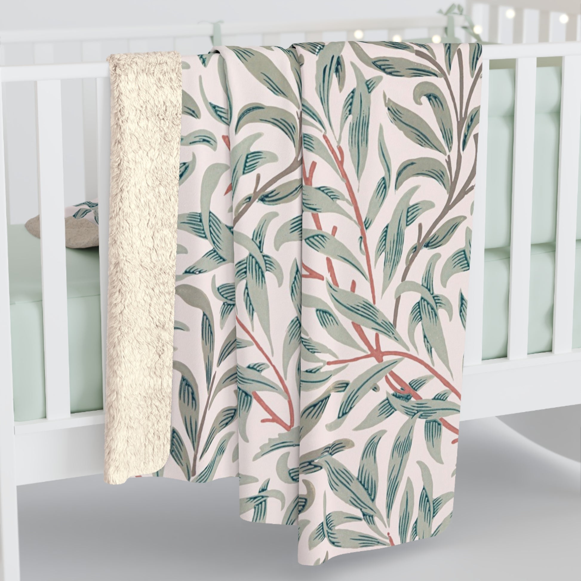Floral-patterned blanket draped over a crib with a white background