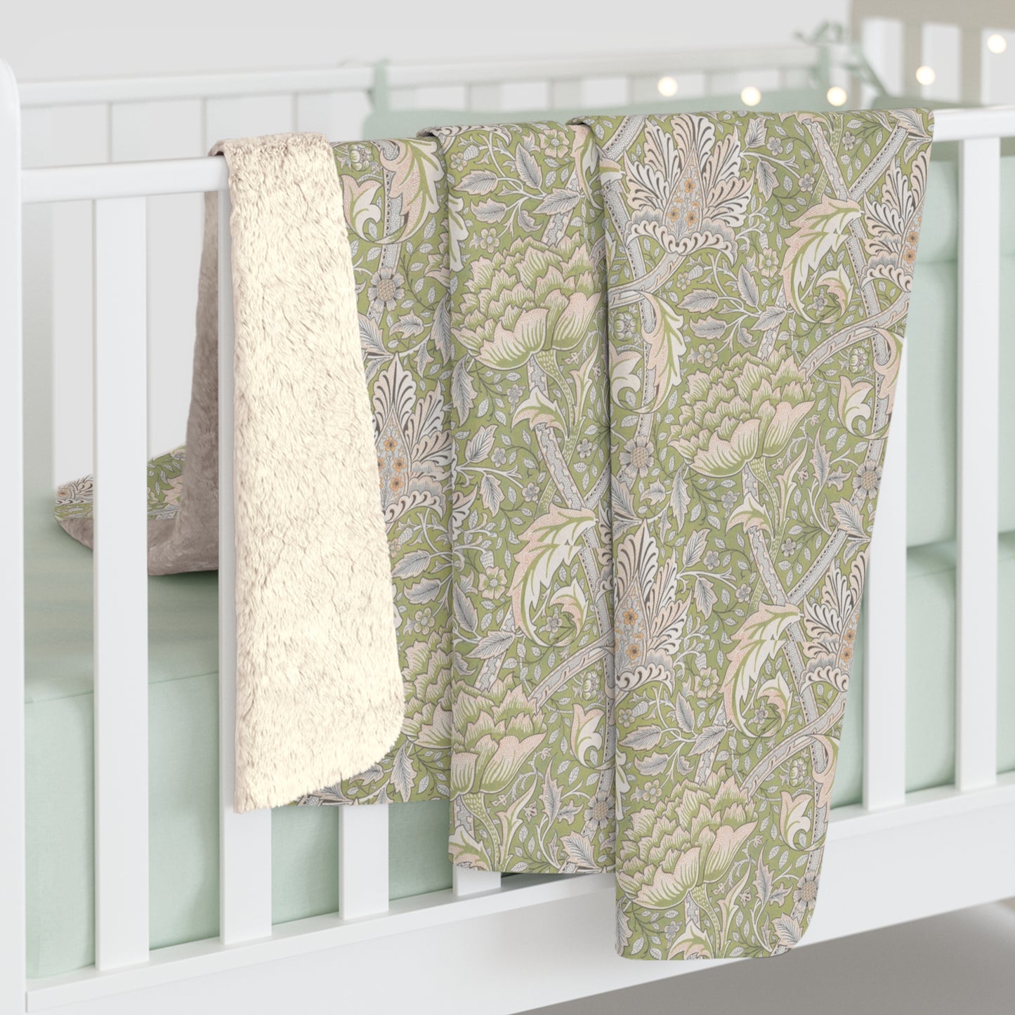 A plush fleece blanket with a floral pattern in green and white tones, inspired by William Morris.