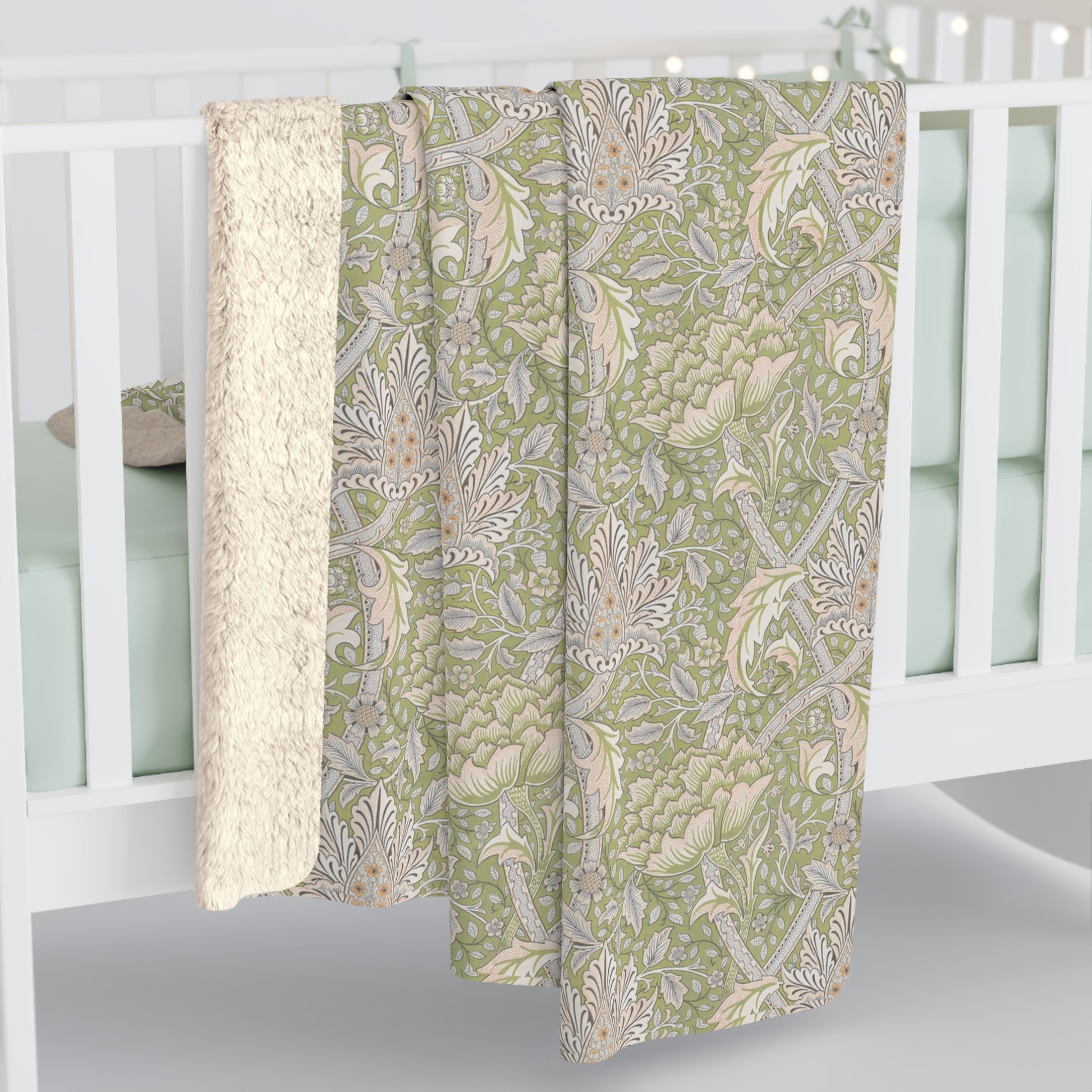 A plush fleece blanket with a floral pattern in green and white tones, inspired by William Morris.