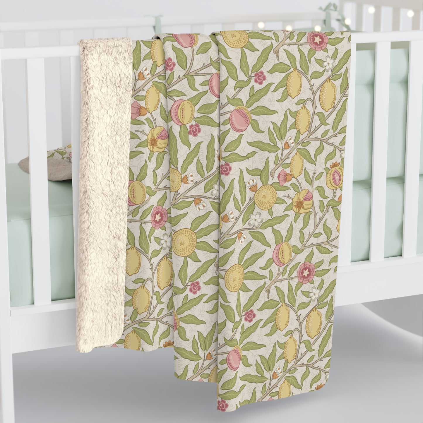 Floral patterned crib sheet with lemons and flowers on a white crib.