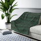 A Sherpa fleece blanket with a floral pattern in green and brown tones, underside showing plush cream sherpa fleece.