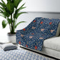 A navy blue Sherpa fleece blanket with a floral pattern inspired by William Morris's design.