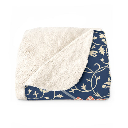 A navy blue Sherpa fleece blanket with a floral pattern inspired by William Morris's design.