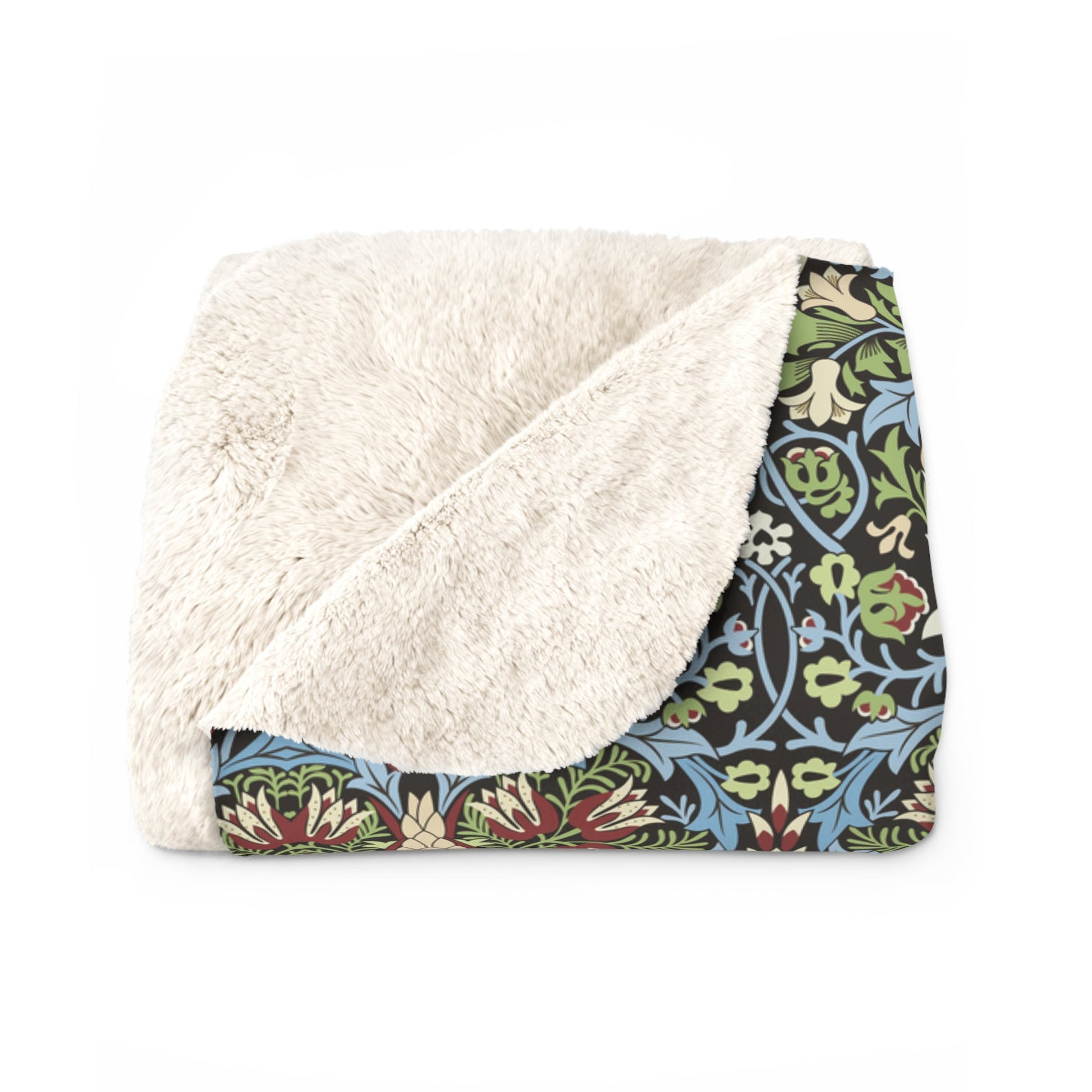 Folded blanket with white sherpa interior and colourful floral pattern on border from William Morris