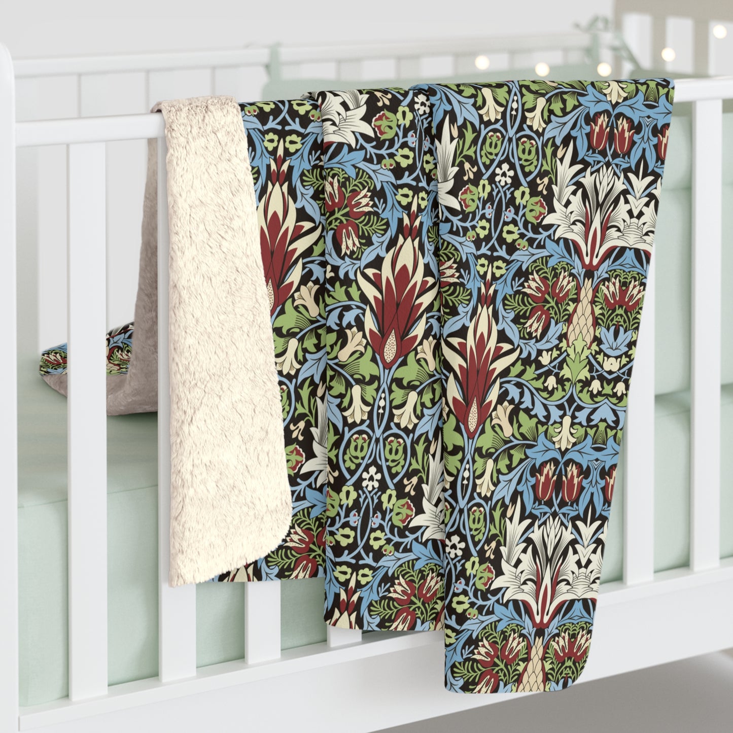Colourful patterned quilt draped over a white crib from William Morris