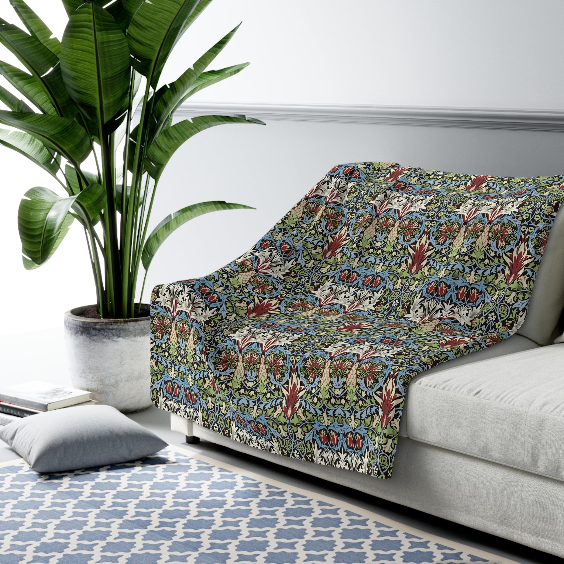 Patterned sofa cover on a white sofa with a plant and rug in the background from William Moris