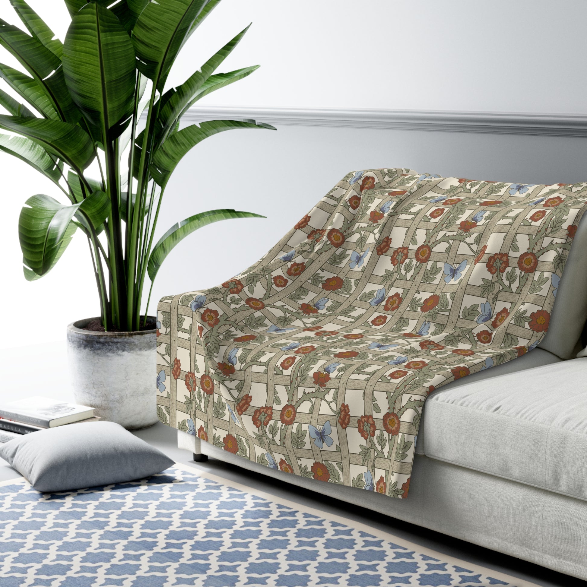 A Sherpa fleece blanket with a floral pattern in beige, green, blue, and red colours on a white background.
