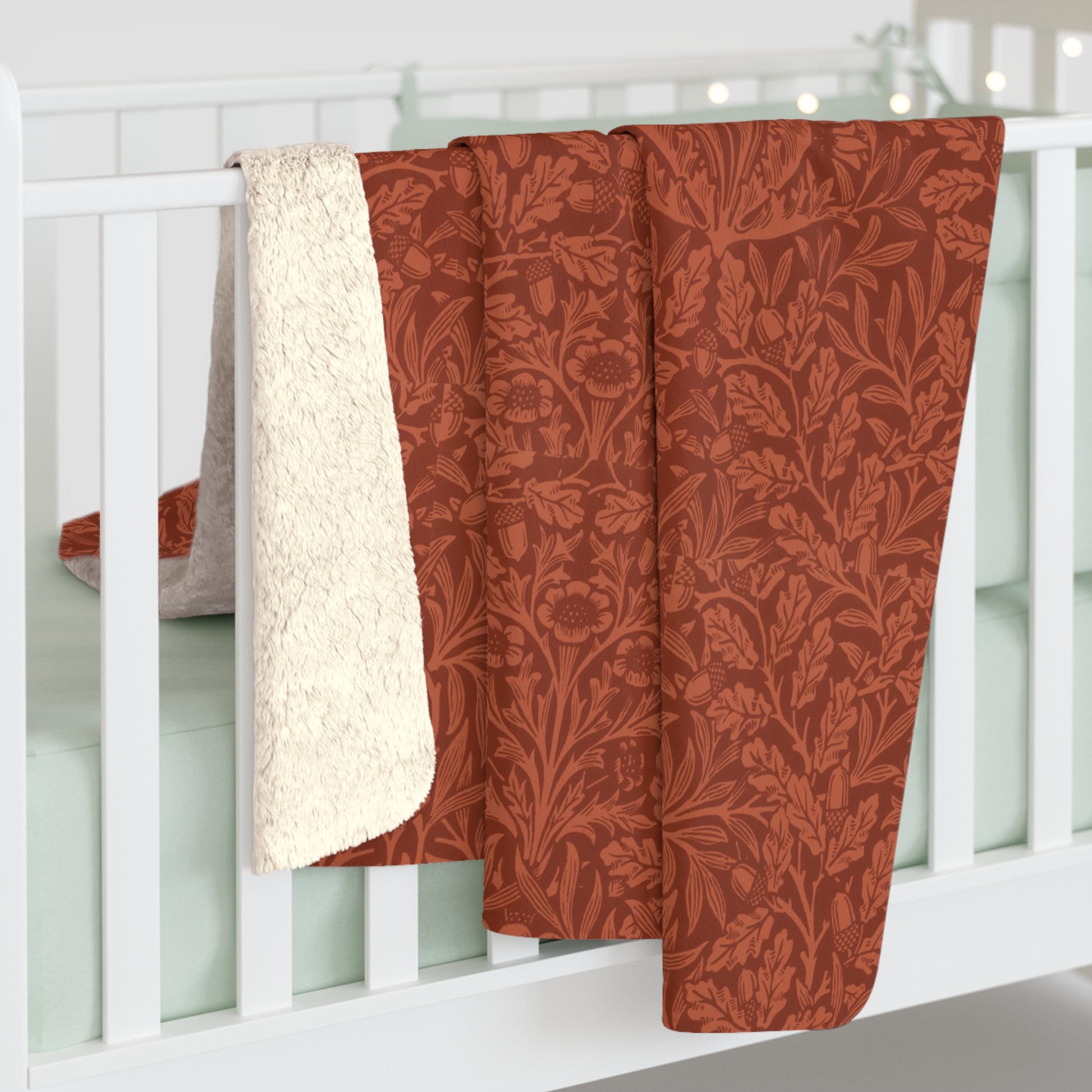 A rectangular Sherpa fleece blanket with a rust-coloured floral pattern inspired by William Morris & Co - Acorns and Oak Trees Collection.