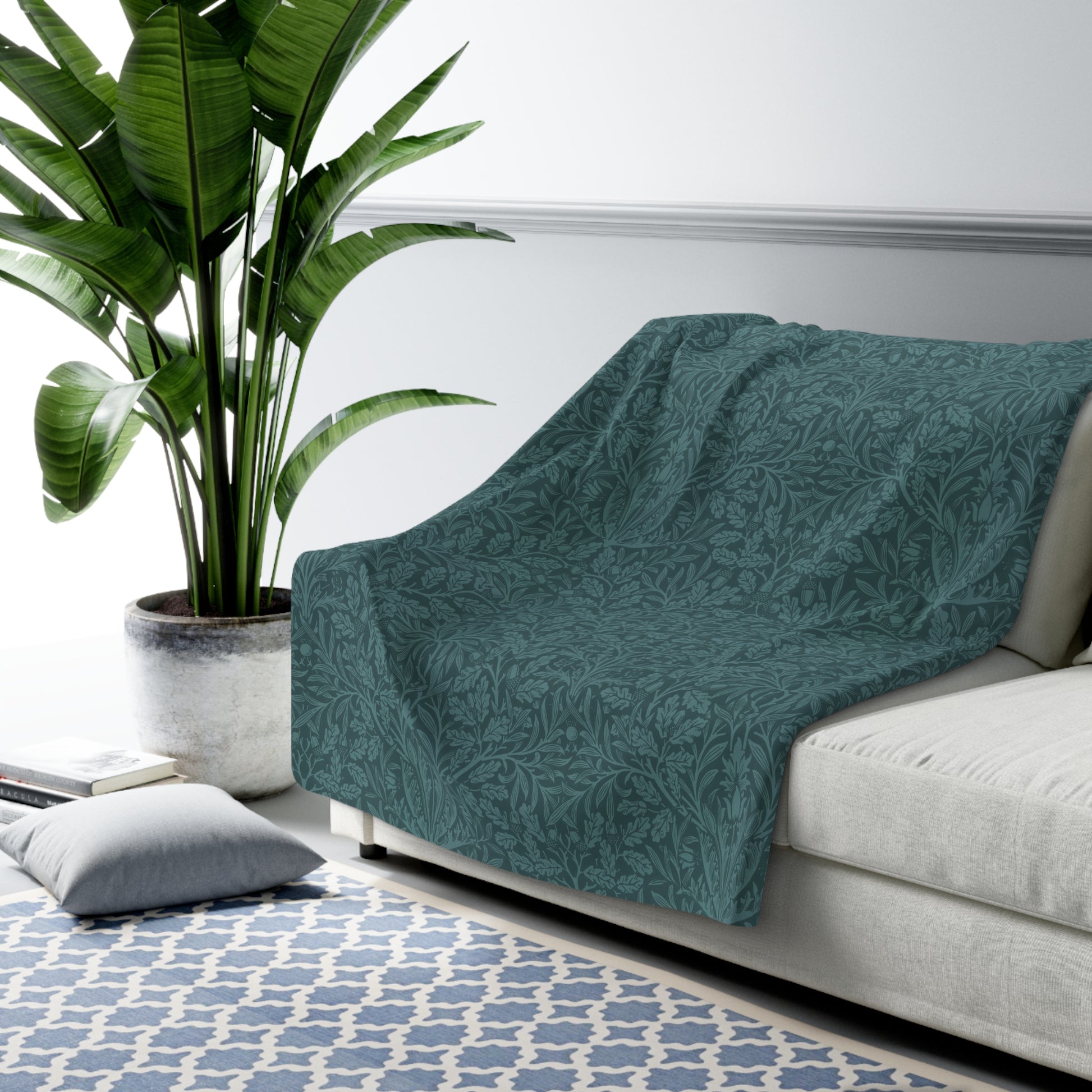 A rectangular Sherpa fleece blanket with a teal colour and a floral pattern inspired by William Morris - Acorns and Oak Trees Collection.