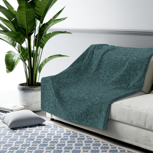 A rectangular Sherpa fleece blanket with a teal colour and a floral pattern inspired by William Morris - Acorns and Oak Trees Collection.
