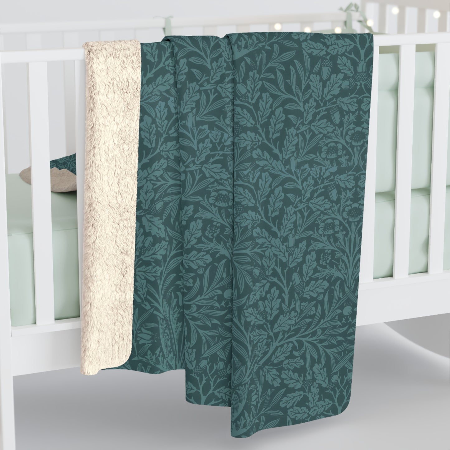 A rectangular Sherpa fleece blanket with a teal colour and a floral pattern inspired by William Morris - Acorns and Oak Trees Collection.